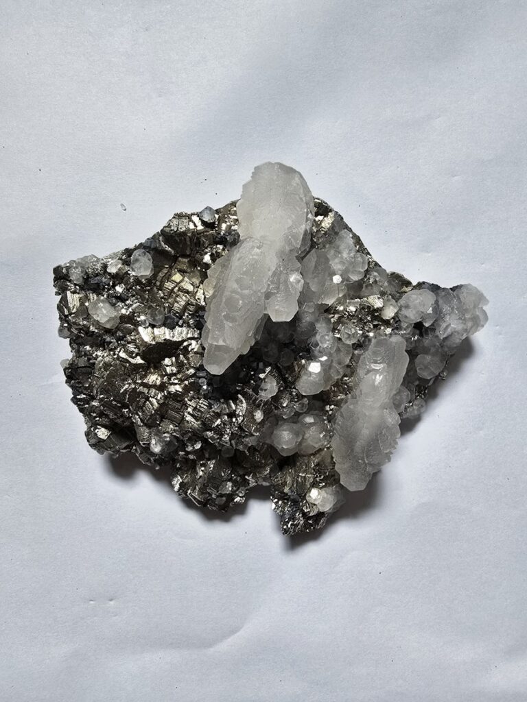 Clear quartz crystals on dark metallic mineral matrix